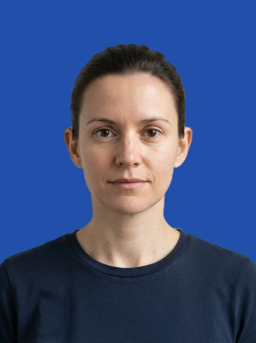 A studio portrait on a royal blue background, as downloaded
