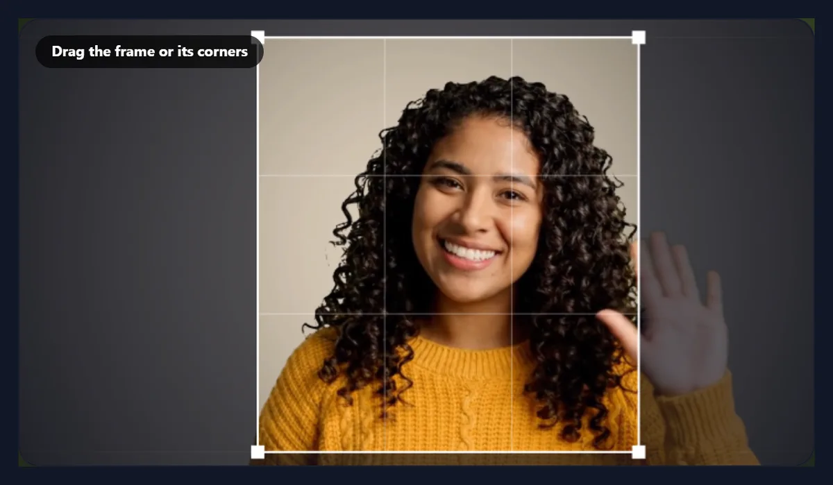 The crop tool with a free crop frame dragged smaller from two corners, framing the woman and her waving hand