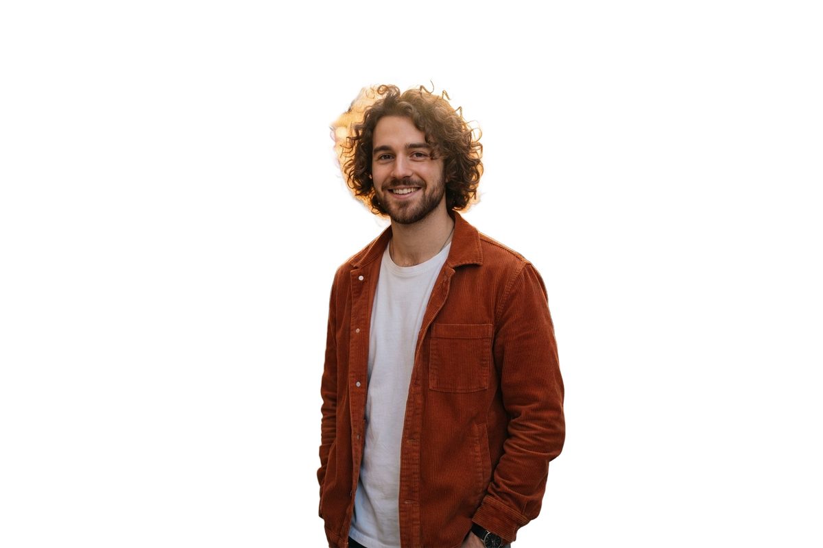 Curly-haired man in a rust jacket on a pure white background after AI cutout